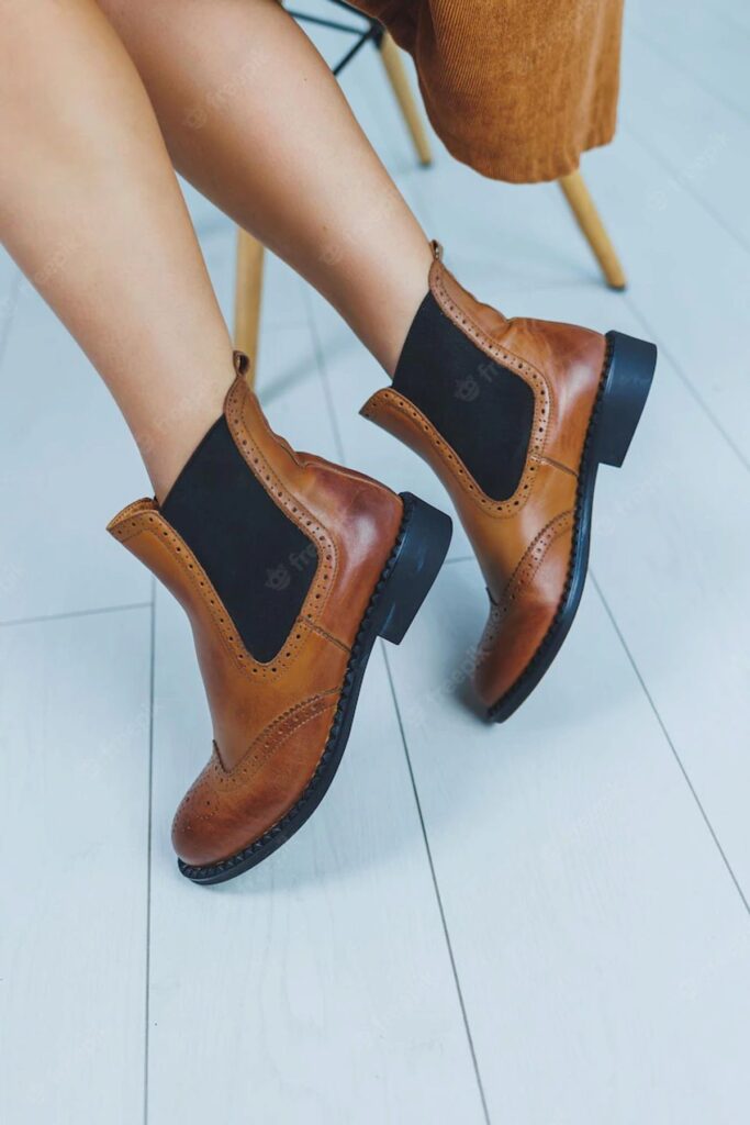 primer-plano-piernas-femeninas-botas-chelsea-cuero-marron-nueva-coleccion-otono-zapatos-cuero-mujer-2022_173815-32190